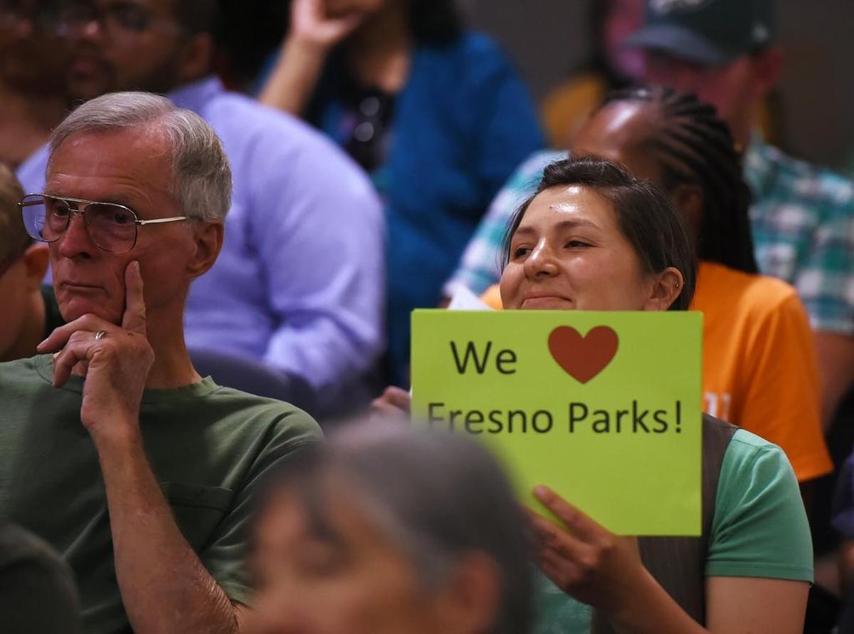 Nikiko Masumoto, right, holds a sign in support of parks as the Fresno City Council met to discuss and vote on the agenda’s parks tax Thursday, Aug. 9, 2018 in Fresno.