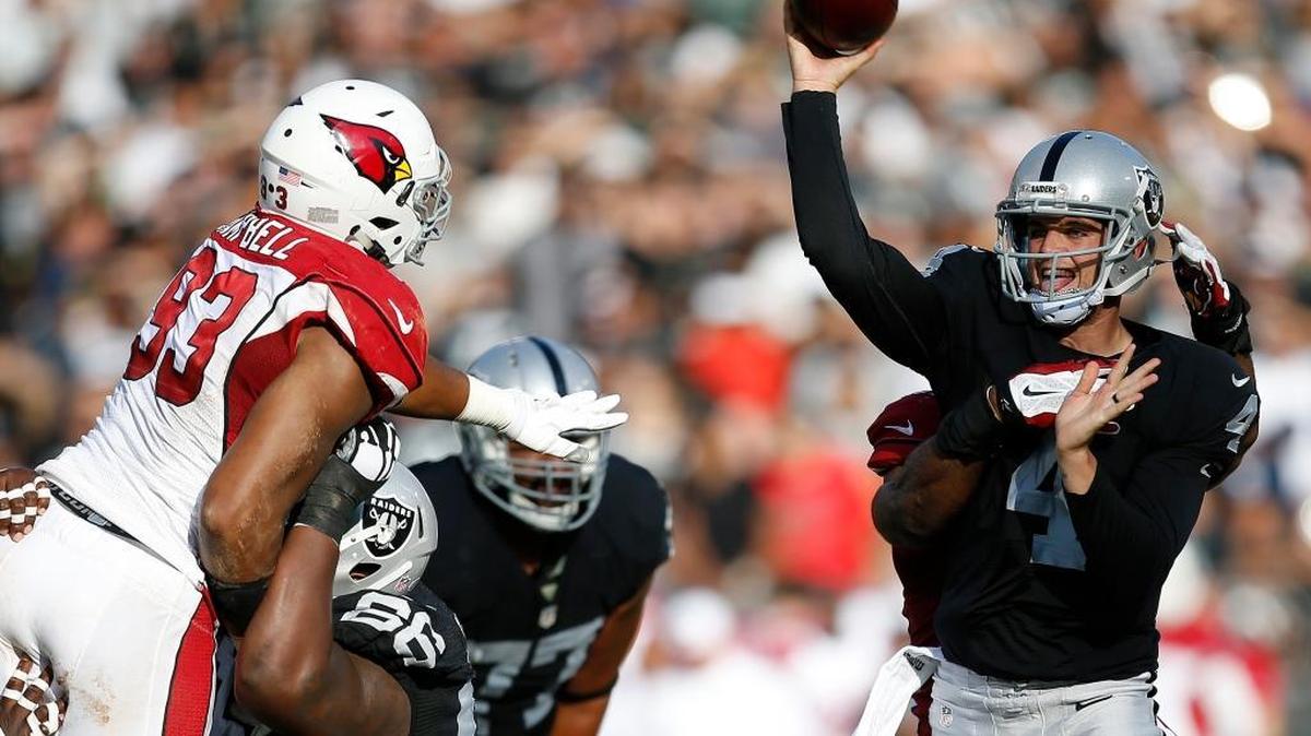 
Oakland Raiders quarterback Derek Carr passes as Arizona Cardinals defensive end Calais Campbell (93) and linebacker Alex Okafor apply pressure during the first half of an NFL preseason football game in Oakland, Calif., Sunday, Aug. 30, 2015.
