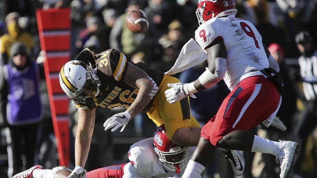 Wyoming fullback Drew Van Maanen fumbles after a hit by Fresno State defensive back Jaron Bryant during Saturday’s game. Jeffrey Allison (9) plucked the football out of the air for a key turnover just before halftime.