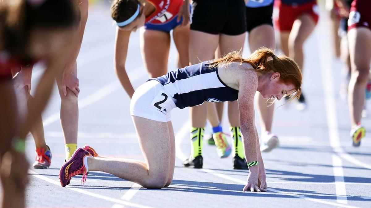 Central Valley Christian’s Gabby Satterlee, center falls to her knees after finishing first in the 1600 at the Central Section Masters Track and Field Championships on May 21, 2016. Temperatures for the CIF championships on June 3-4 at the same venue are expected to reach the mid-100s.