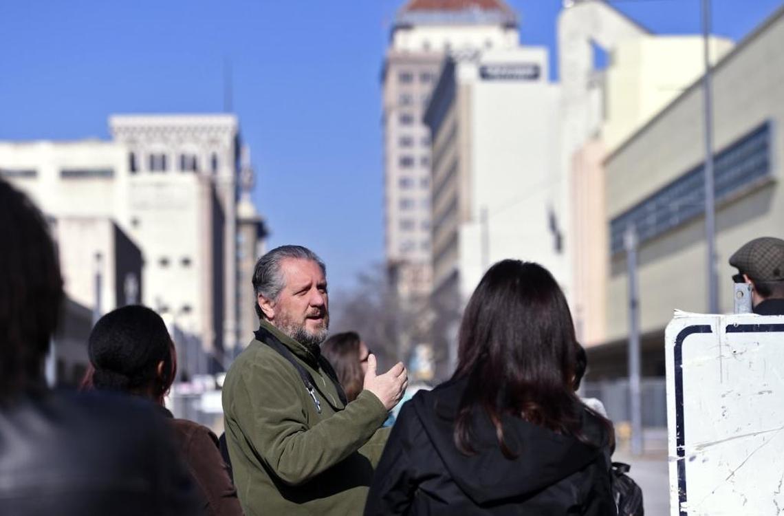 Craig Scharton, center, interim president and CEO of the Downtown Fresno Partnership, leads one of his regular walking tours along the transforming Fulton Street in downtown Fresno.