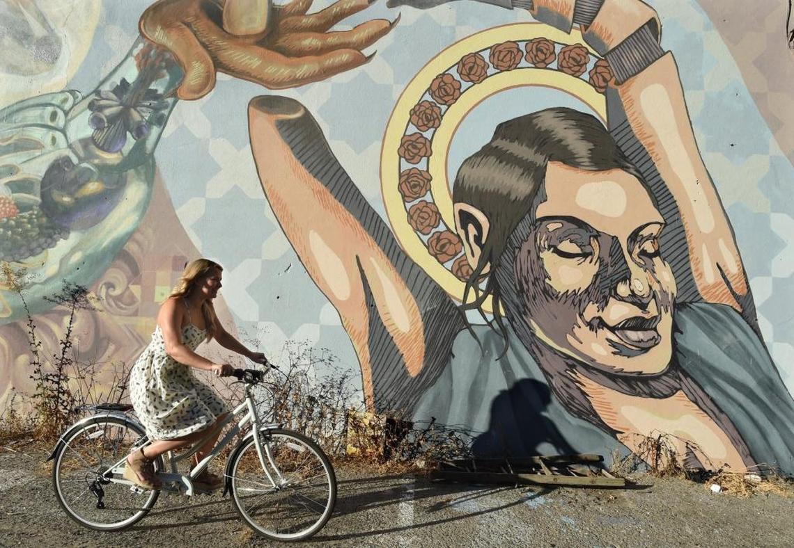 Downtown Fresno resident Jordan Gustafson bikes past one of the many downtown Fresno murals. The 31-year-old Bitwise employee grew up on a Clovis farm and wanted nothing to do with downtown Fresno while working inside sales for the Fresno Grizzlies. However, her perspective on urban living completely changed after she spent six years in New York City.