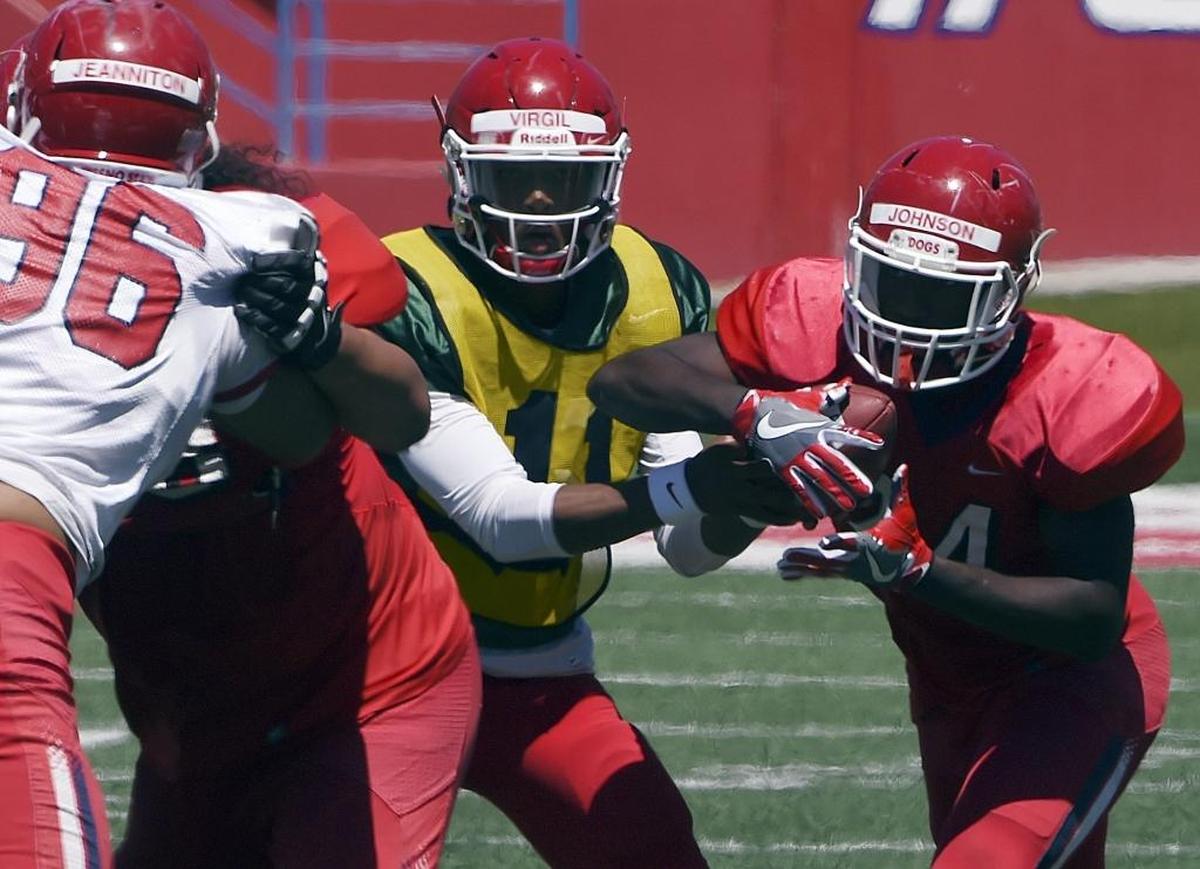 Saevion Johnson, right, takes a handoff from quarterback Chason Virgil during Fresno State’s April 29 Spring Preview at Bulldog Stadium. The Pearland, Texas, native is the best pure runner among the returning tailbacks, Bee columnist Marek Warszawski writes.