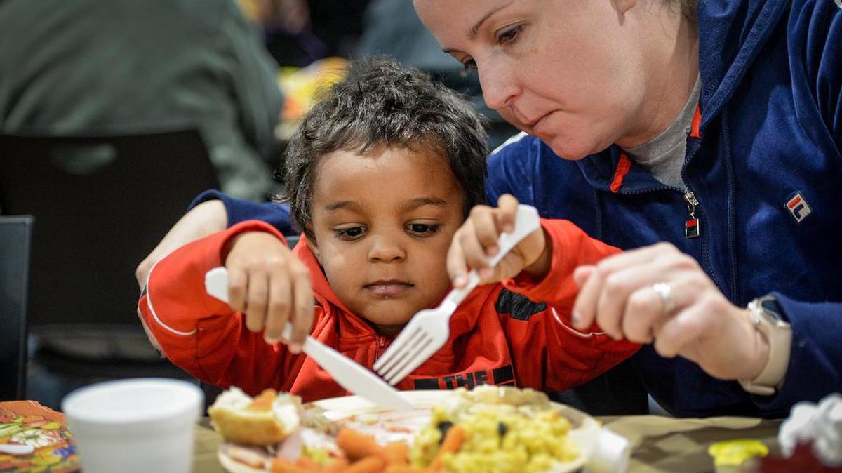 Gabriel Carter, 3, gets some help from his mother, Sarah Carter, while enjoying a Thanksgiving meal at the Fresno Rescue Mission during their annual Thanksgiving Luncheon on Tuesday, Nov. 26, 2019.