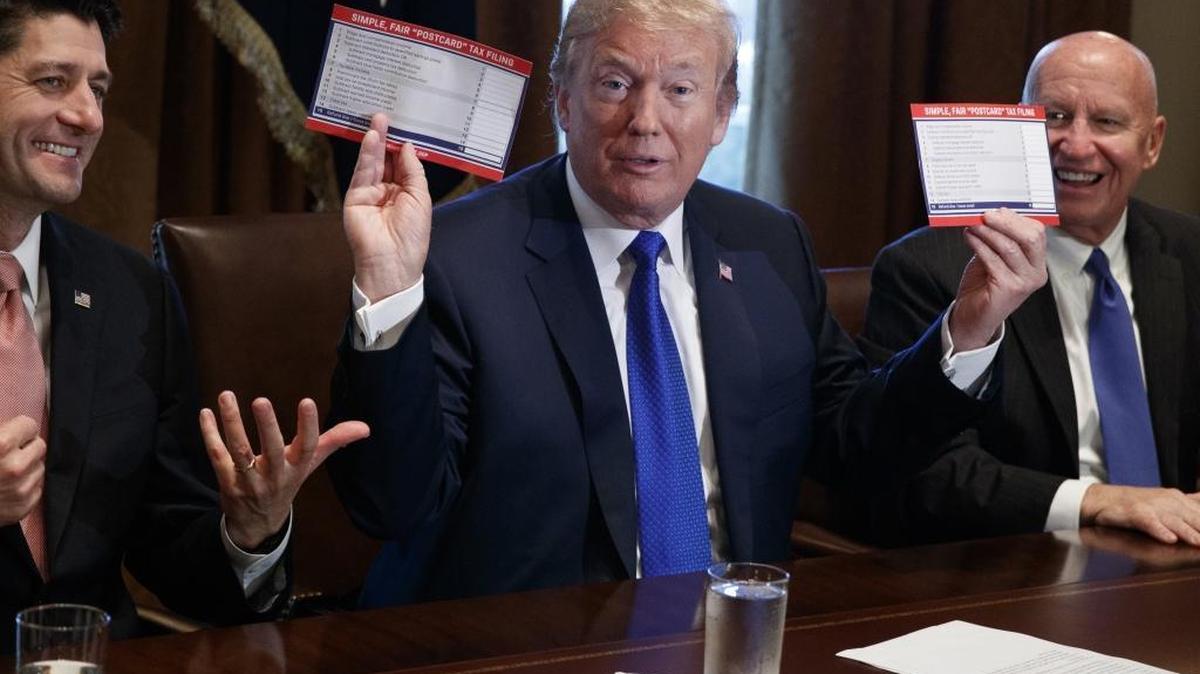 President Donald Trump holds an example of what a new tax form may look like during a meeting on tax policy with Republican lawmakers including House Speaker Paul Ryan of Wis., and Chairman of the House Ways and Means Committee Rep. Kevin Brady, R-Texas, right, in the Cabinet Room of the White House on Nov. 2.