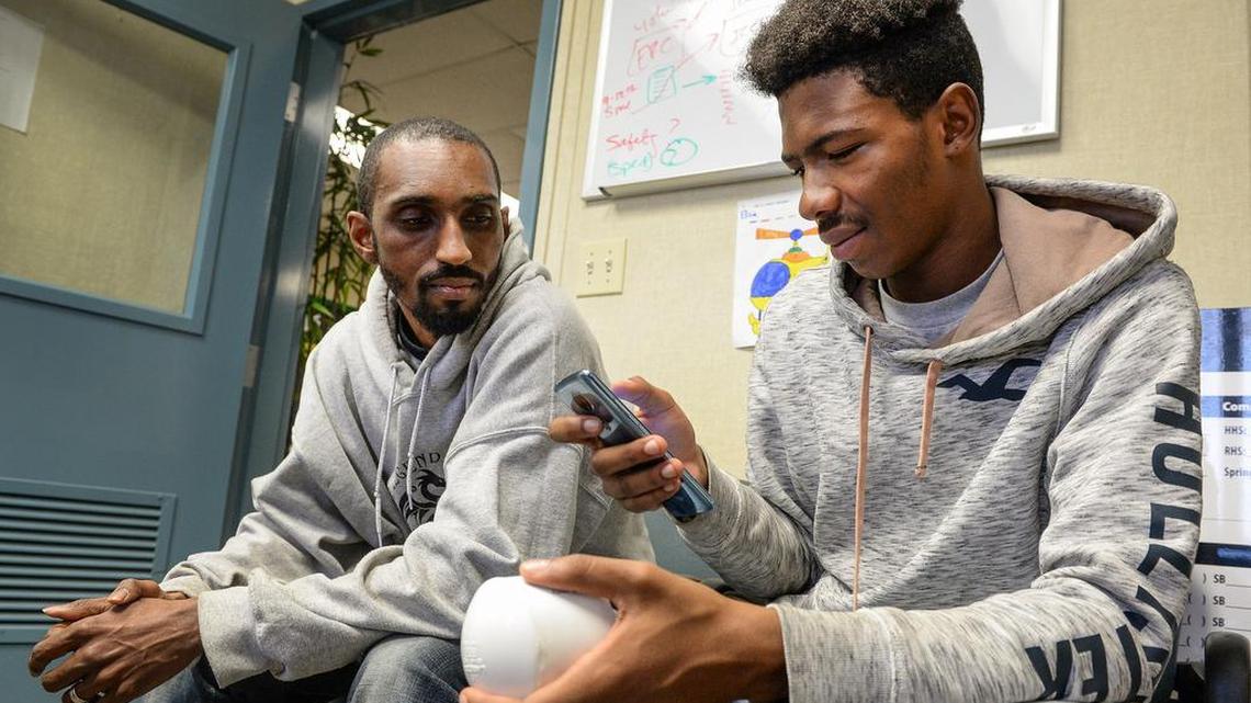 Kieshaun White, right, an 18-year-old who grew up in SW Fresno and has been detailing differences in air quality between north and south Fresno, configures an air quality monitor with help from his mentor Marcel Woodruff at Phoenix High School on Tuesday, Dec. 11,2 018. White is working to install air quality monitors at high schools throughout Fresno Unified School District and developing an app so people can check air quality in real time on those school campuses.