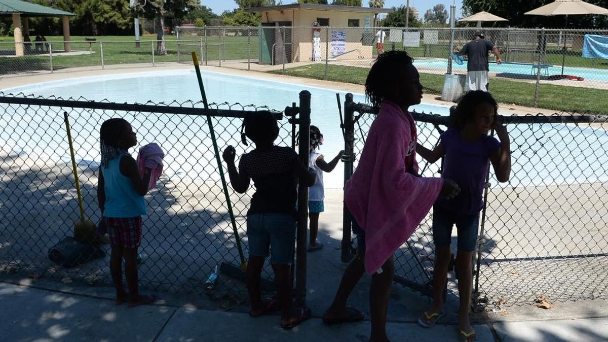 Kids wait for the pool to open at Fink-White Park in southwest Fresno on July 8, 2013.