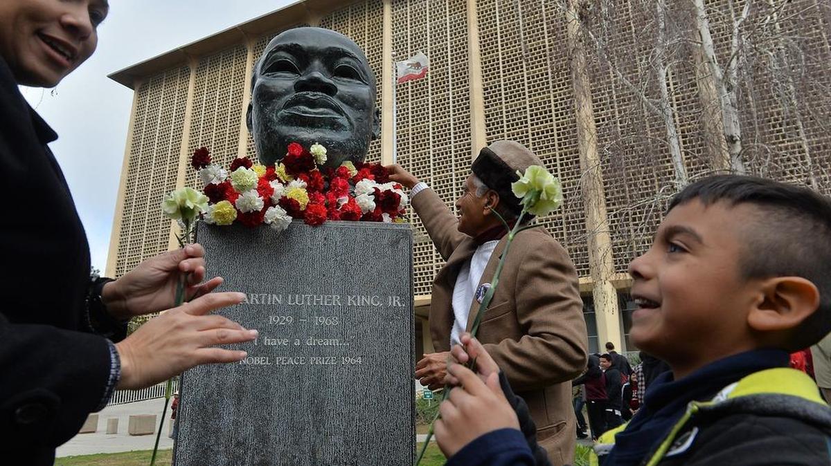 Students line up to place a carnation on the MLK statue during the 2017 Rev. Dr. Martin Luther King Jr. Celebration Opening Garlanding Ceremony at Fresno County Courthouse Park.