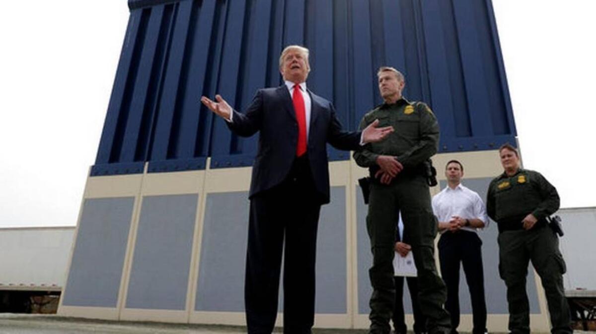 President Donald Trump speaks during a tour as he reviews border wall prototypes, Tuesday in San Diego, as Rodney Scott, the Border Patrol's San Diego sector chief, listens.