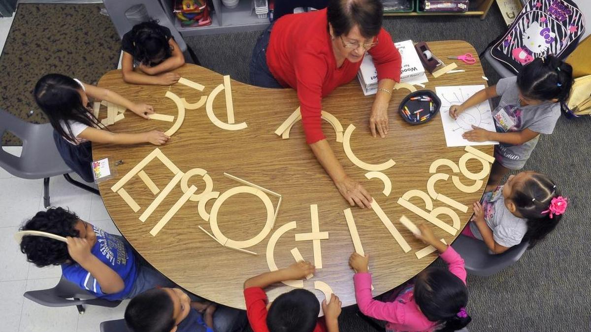 In this 2014 file photo, Jefferson Elementary teachers aide Amparo Espinoza works with 4-year-olds in forming letters from pieces of wood in their transitional kindergarten class. The class gives children an extra boost in learning readiness. More recently, the Fresno Unified school became one of the first designated schools in the district. Principal Kali Isom-Moore said it’s not just the additional instructional time that happens at a designated school, but the flexibility and collaborative nature of the program that made a difference.