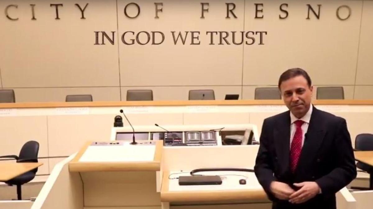 In a screen capture from a YouTube video, Fresno City Councilman Garry Bredefeld shows what adding the national motto ‘In God We Trust’ to the front wall of the City Council chamber might look like.