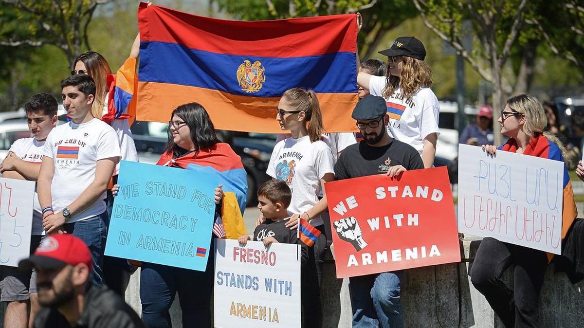 Armenians and community members hold signs and flags while listening to speakers during the annual Armenian flag-raising ceremony to commemorate the victims and survivors of the Armenian Genocide. The event was held outside Fresno City Hall on April 21, 2018.