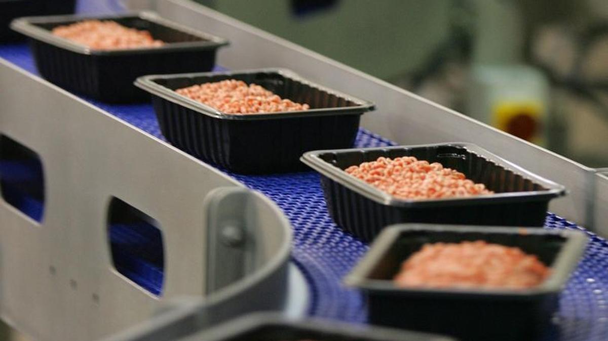 Ground beef rolls along an assembly line toward its plastic wrap at the Cargill beef processing plant in southwest Fresno.