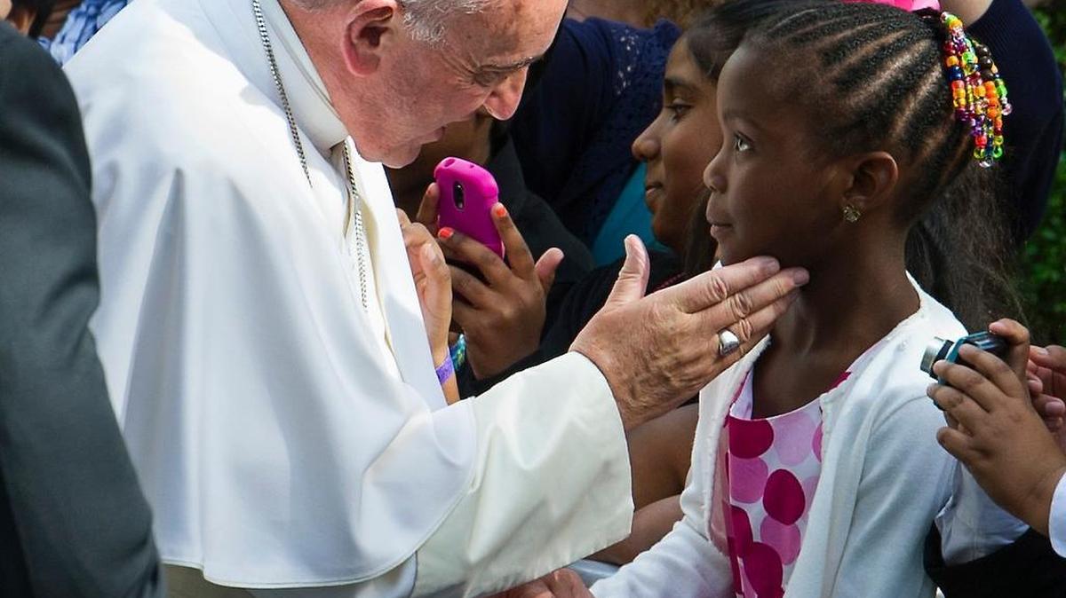 
Pope Francis touches the cheek of a young girl as he prepares to depart the Apostolic Nunciature, the Vatican's diplomatic mission in Washington. 
