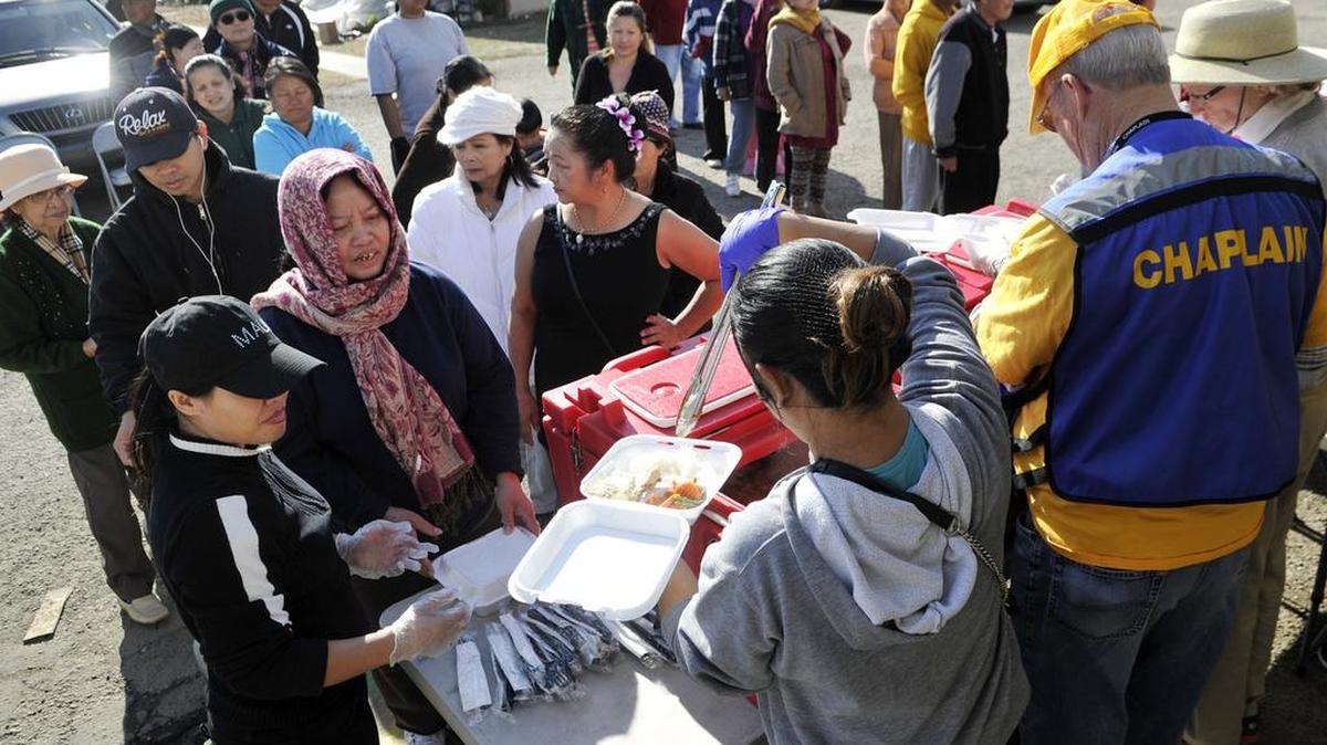 Tenants of Summerset Village Apartments line up for lunch offered by area church volunteers at a tent operated by the American Red Cross and the Southern Baptist Convention Disaster Relief group Nov. 30, 2015.