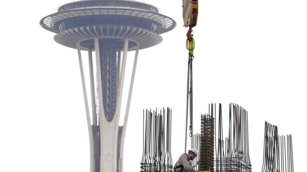A construction worker puts in framing for a new high-rise building in view of the Space Needle in the South Lake Union neighborhood of Seattle in February 2015.