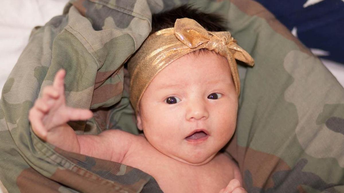 
In my all-time favorite OpLove session, a mid-deployment one, I worked to capture photos of a newborn girl whose dad had not met her yet. We wrapped the newborn in the fatigues of her grandfather and used the flag that shrouded his coffin in the background; I later heard that the photo moved dad to tears when he received it.
