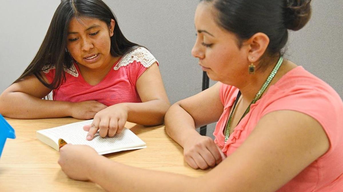 Itzel Garcia, left, of Roosevelt High School reads a book while being tutored by Martha Fregoso at the Boys & Girls Club in Fresno. Garcia was born in Oaxaca, Mexico, and is an English learner and is getting tutoring help for her English class finals from Reading and Beyond tutors.
