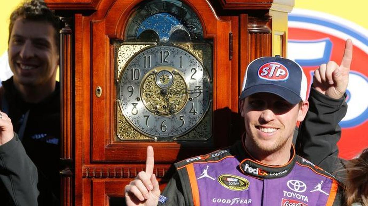 Denny Hamlin poses next to the winner’s trophy after the NASCAR Sprint Cup Series auto race at Martinsville Speedway in Martinsville, Va., last March.