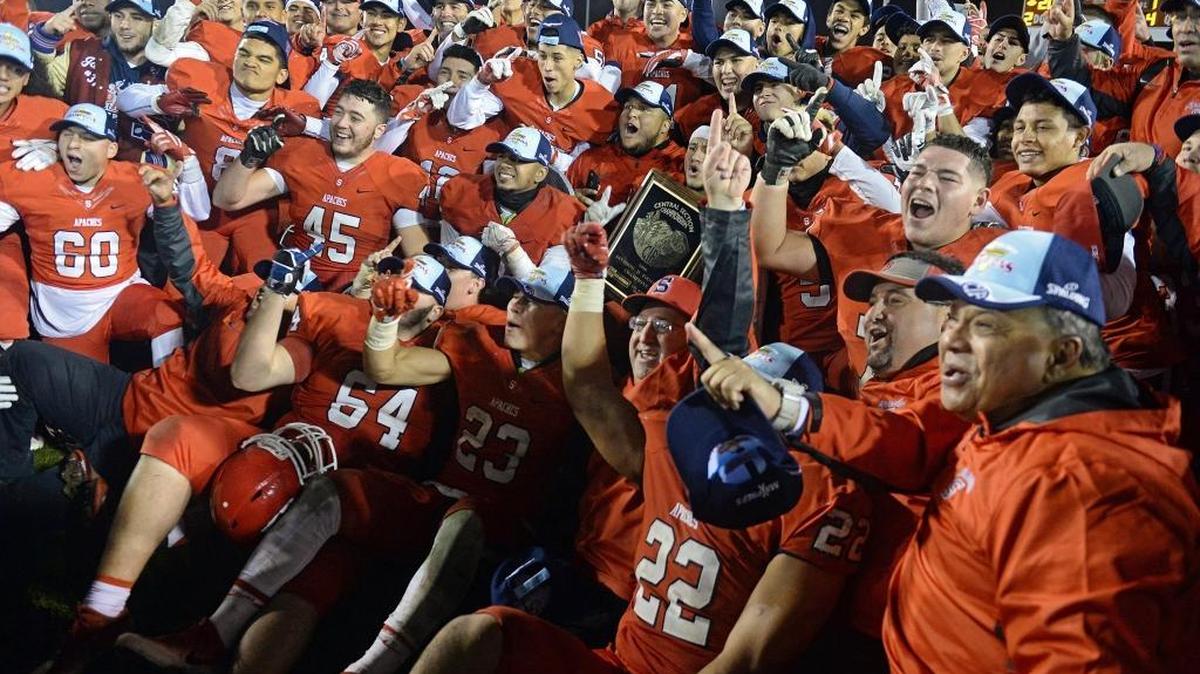 Members of the Sanger football team and coaching staff celebrate their Central Section Division II championship after beating Ridgeview 20-10 at Sanger Friday, Dec. 2, 2016.