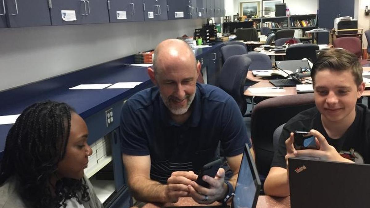 Ananda Shaffer of Sunnyside High School and Luke Colvard of Clovis High School discuss with their teacher, Adam Higginbotham, an app they downloaded to complete an assignment. Higginbotham teaches in the Center for Advanced Research and Technology in Clovis. He specializes in the Law and Policy lab.