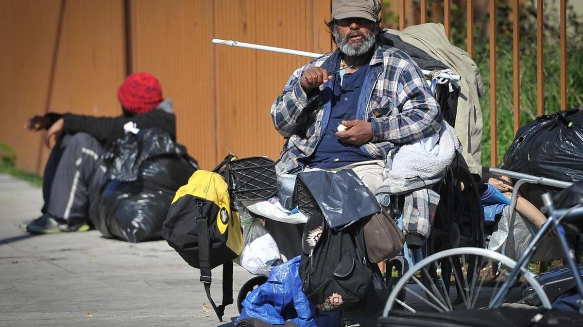 A homeless man watches the first annual Memorial Service for Fresno Area Homeless, near the Poverello House, on Feb. 14.