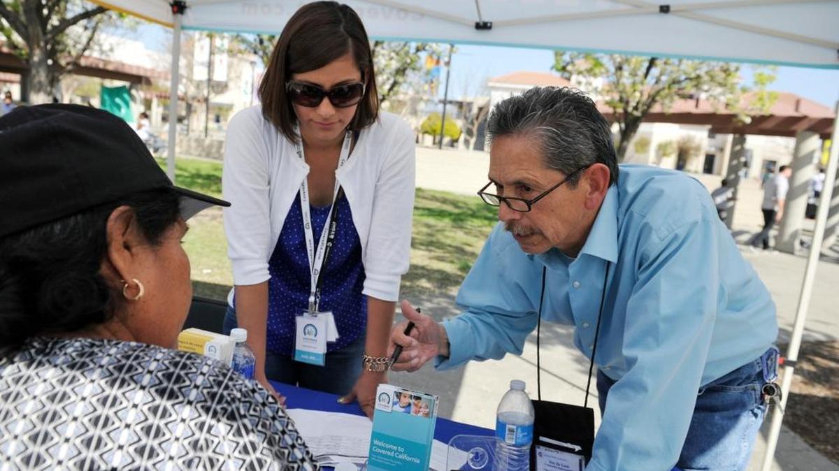 Covered California’s Gina Falcon, center, and Roy De Leon, right, answer questions during outreach at Sunnyside High School in Fresno on March 15, 2014. Hundreds of thousands of Valley families would lose health-care coverage if the Senate passes the bill approved by the House on Thursday, May 4, 2017.