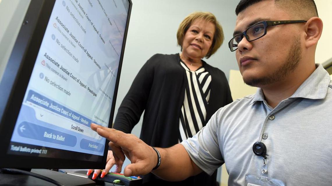 Daniel Garcia, Madera County deputy clerk, demonstrates the electronic Dominion Voting System, as Rebecca Martinez, Madera County clerk, looks on in the elections office, Monday Jan. 14, 2019. The devices proved successful and popular with voters in the 2018 election.