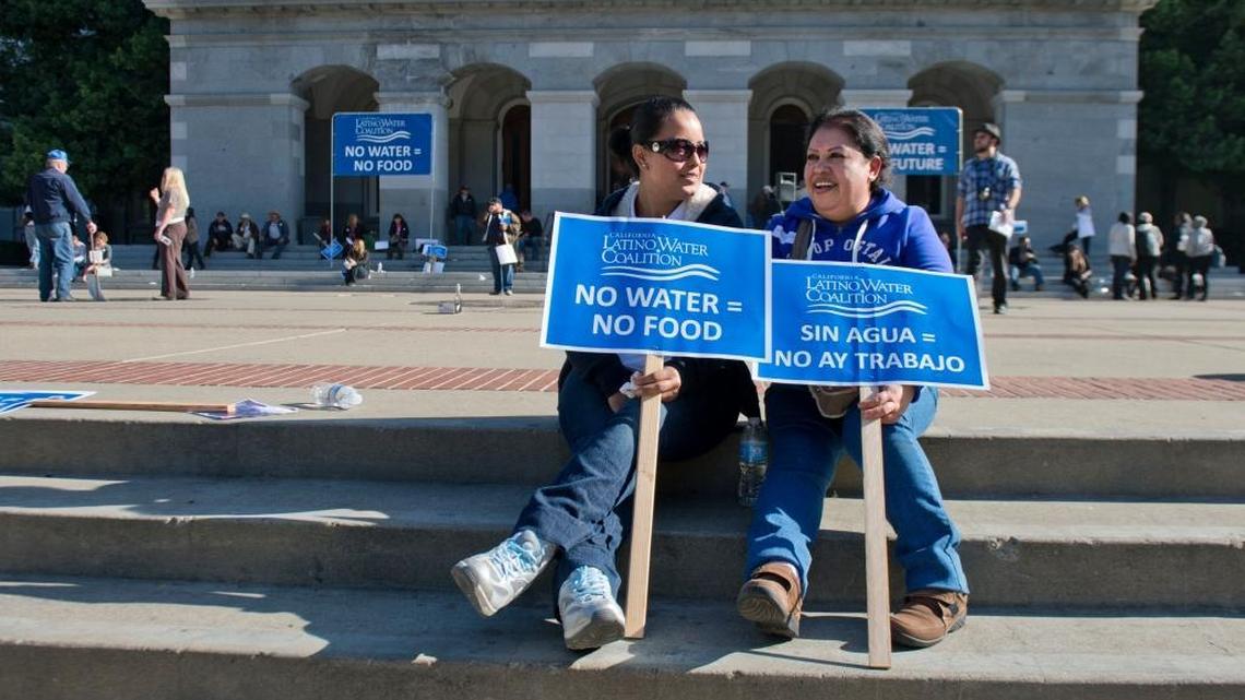 Beatriz De Anda of Mendota and Olivia Gallardo of Kerman, who work at an almond packaging plant in Mendota, hold signs in support of a water bond after hundreds rallied at the Capitol in 2014.