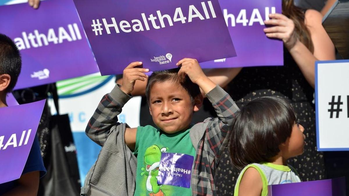 A child holds up a #Health4All poster at an event about expanding Medi-Cal coverage to undocumented children at Clinica Sierra Vista in Fresno in 2016.