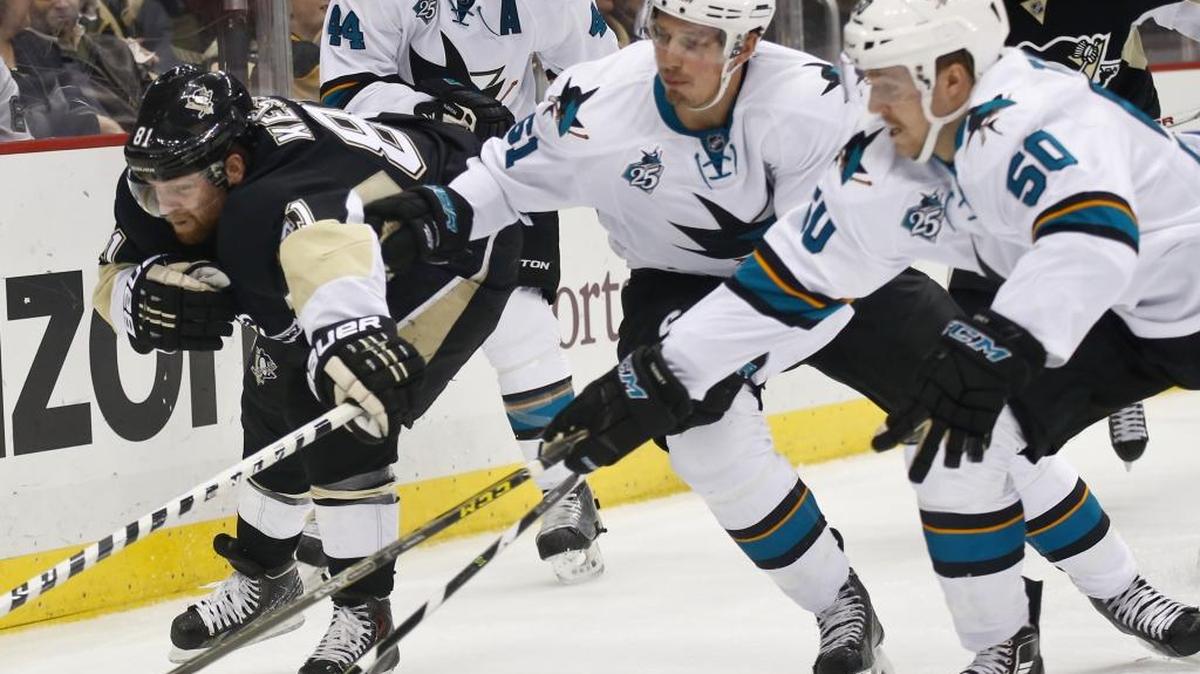 Pittsburgh Penguins forward Phil Kessel, left, tries to skate away from San Jose Sharks players in the second period of an NHL hockey game Sunday, Nov. 22, 2015, in Pittsburgh. The Sharks won 3-1.