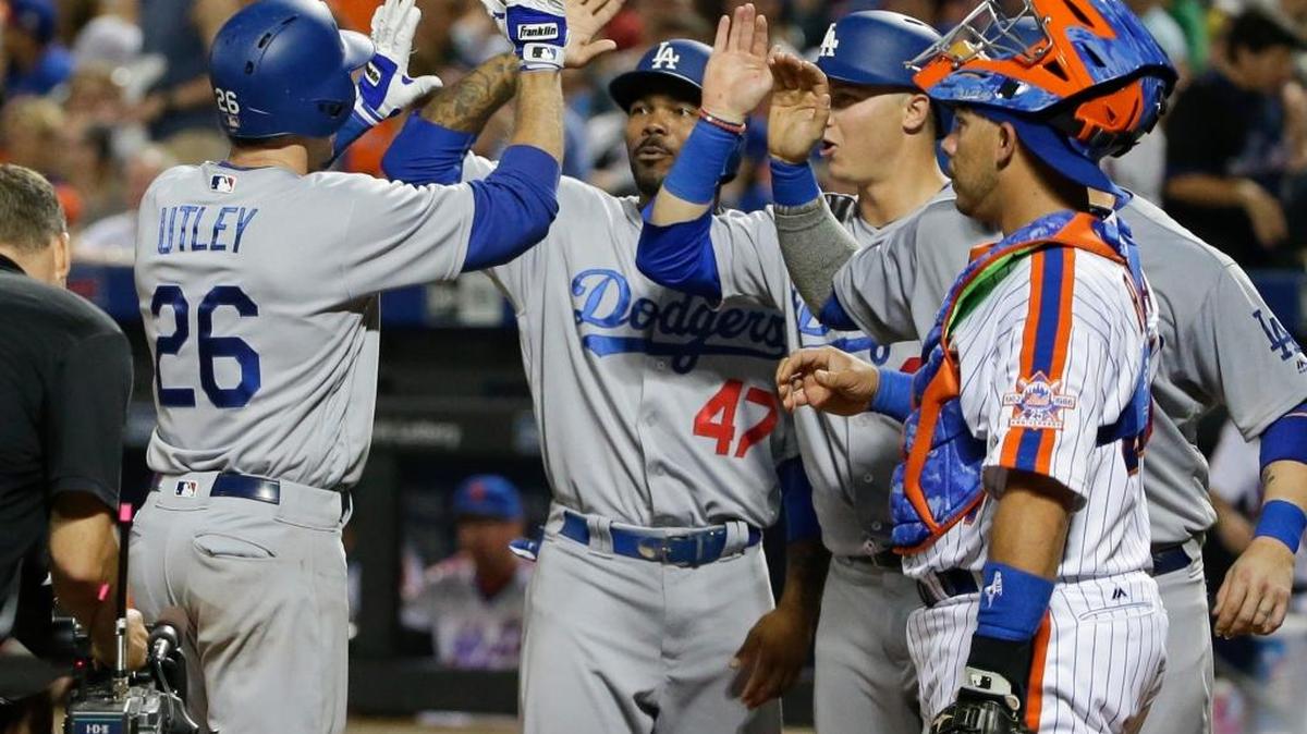 New York Mets catcher Rene Rivera watches as Los Angeles Dodgers infielder Chase Utley (26) celebrates with teammates after hitting a grand slam during the seventh inning of a baseball game Saturday, May 28, 2016, in New York.
