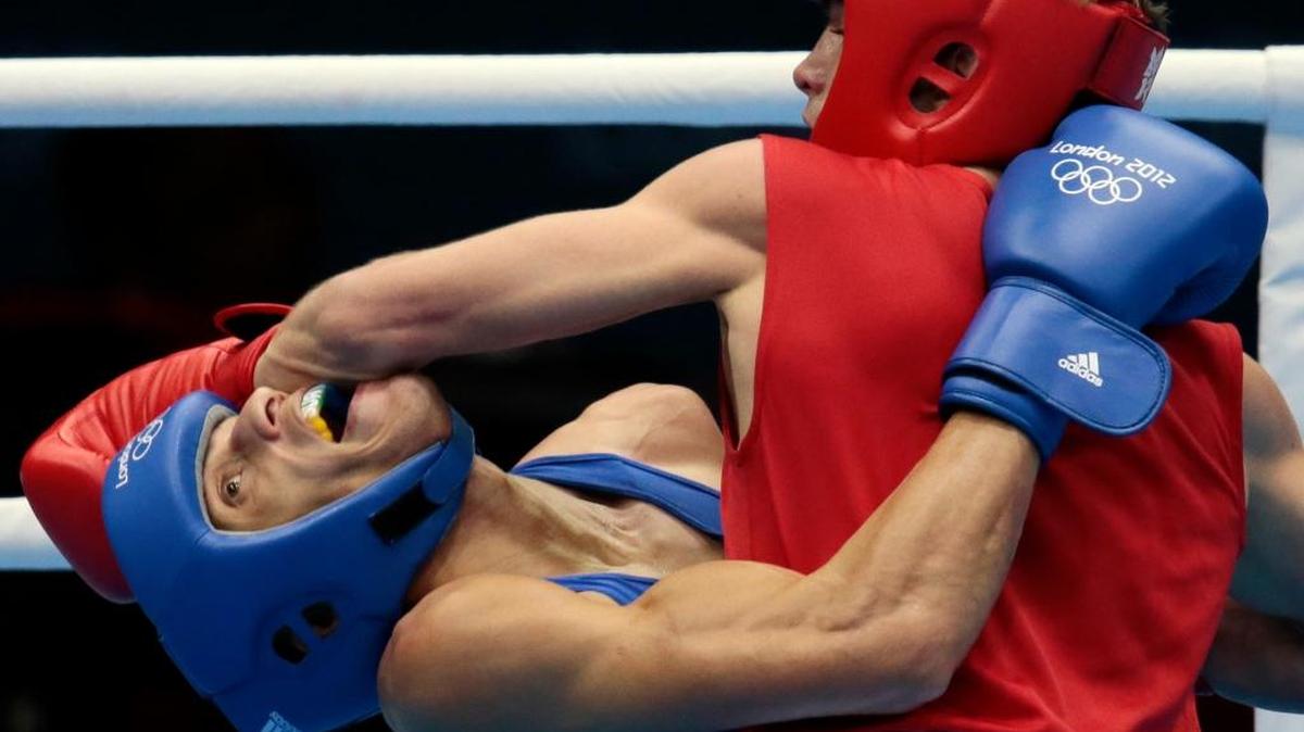 In this Aug. 1, 2012, file photo, Russia’s Sergey Vodopiyanov, right, fights Brazil’s Robenilson Vieira de Jesus, during their men’s bantamweight boxing match at the 2012 Summer Olympics in London. The International Boxing Association’s plan to eliminate headgear, at least on the surface, would make the sport inherently more dangerous.