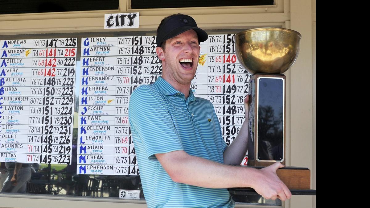 
Former Santa Clara golfer Jonathan Keane celebrates with the hardware after winning the 88th Fresno City Amateur Men’s Championship at Riverside Golf Course on Monday.
