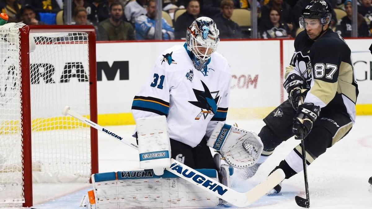 Pittsburgh Penguins center Sidney Crosby, right, looks for a rebound as San Jose Sharks goalie Martin Jones deflects a shot in the second period of an NHL hockey game Saturday, Nov. 21, 2015, in Pittsburgh.