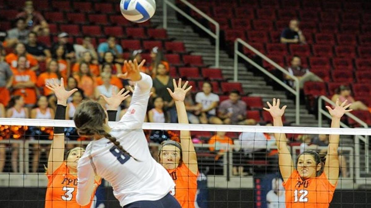 Fresno State’s Taylor Slover goes for a kill Tuesday night against Fresno Pacific’s front line of, from left, Caroline Bodziak, Kylei Dewar and Hannah Miller.