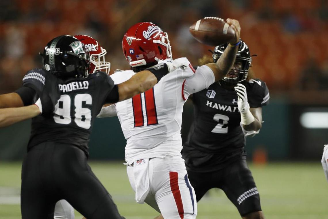 Hawaii defensive lineman Kaimana Padello (96) strips the ball away from Fresno State quarterback Jorge Reyna (11) causing a fumble during the first half of the Bulldogs’ 41-38 victory over the Rainbow Warriors Saturday, Nov. 2, 2019, in Honolulu.