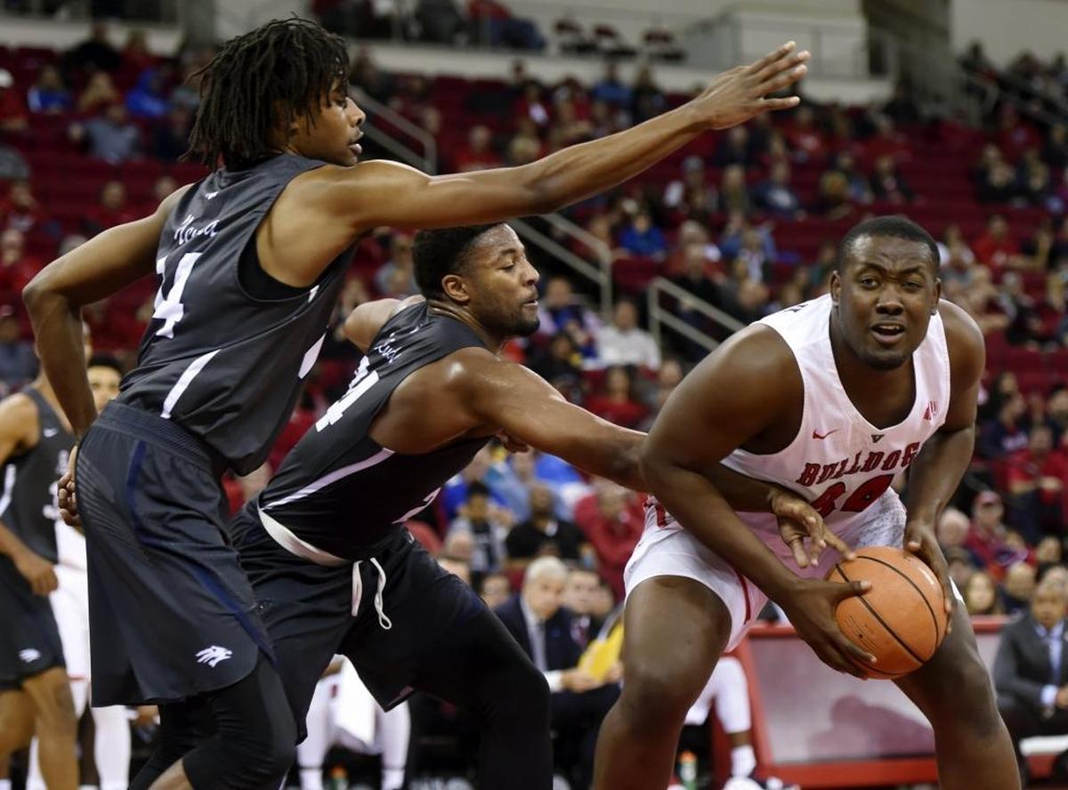 Nevada’s Lindsey Drew, far left, and Jordan Caroline guard Fresno State center Terrell Carter III in the Bulldogs’ 80-65 loss to the Wolf Pack in a Mountain West Conference opener Wednesday, Dec. 27, 2017, at Save Mart Center.