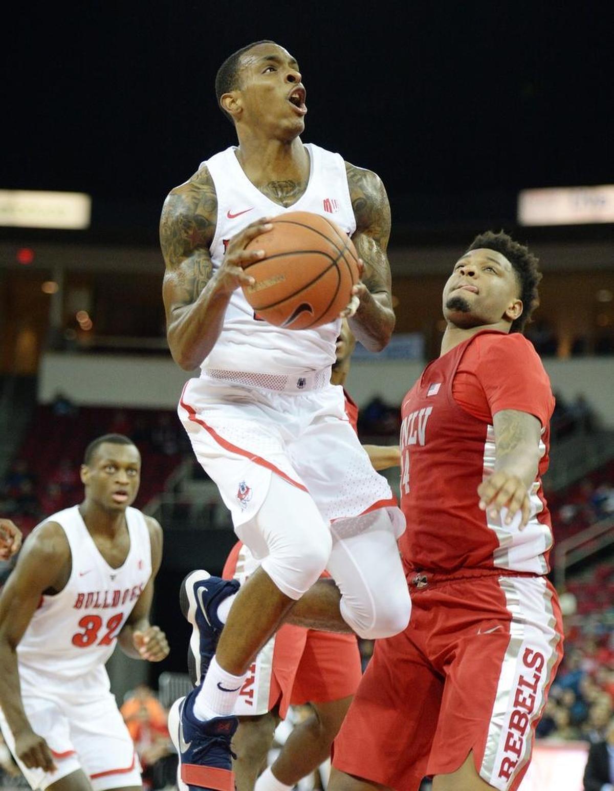 Fresno State guard Deshon Taylor, center, drives by UNLV's Tervell Beck in the first half of the Bulldogs’ 69-63 victory over the Rebels at the Save Mart Center in Fresno on Tuesday, Jan. 23, 2018. Taylor scored 13 points and had five rebounds in the victory.