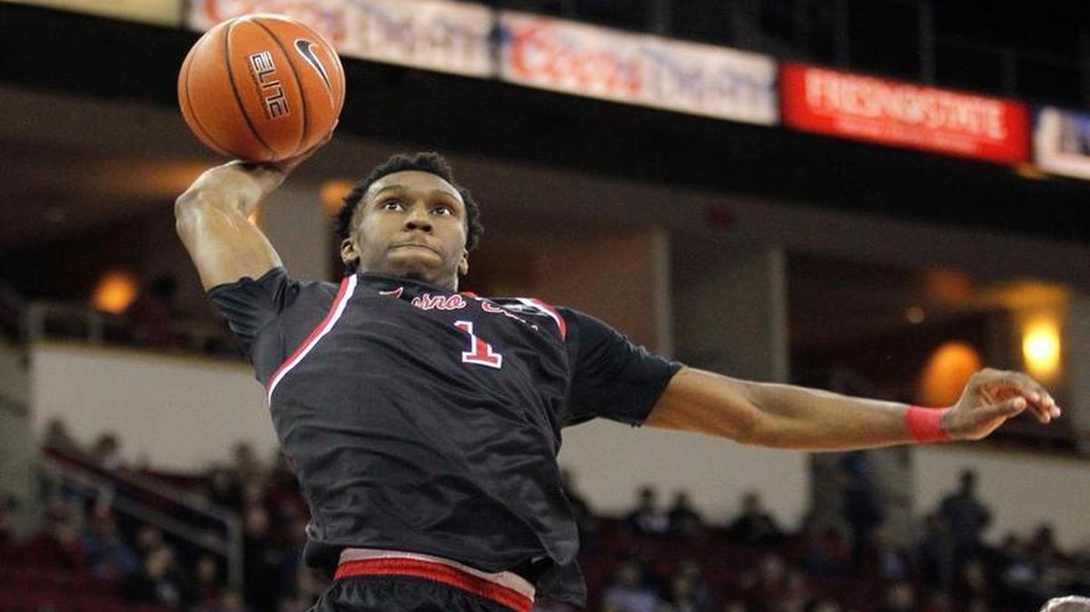 Fresno State point guard Jaron Hopkins drives for a dunk against New Mexico's Obij Aget late in the Bulldogs’ victory over the Lobos on Feb. 18, 2017, at the Save Mart Center in Fresno, Calif. Hopkins over the past 14 games has averaged 14.7 points, 5.6 rebounds, 3.7 assists and 2.0 steals per game for the Bulldogs.