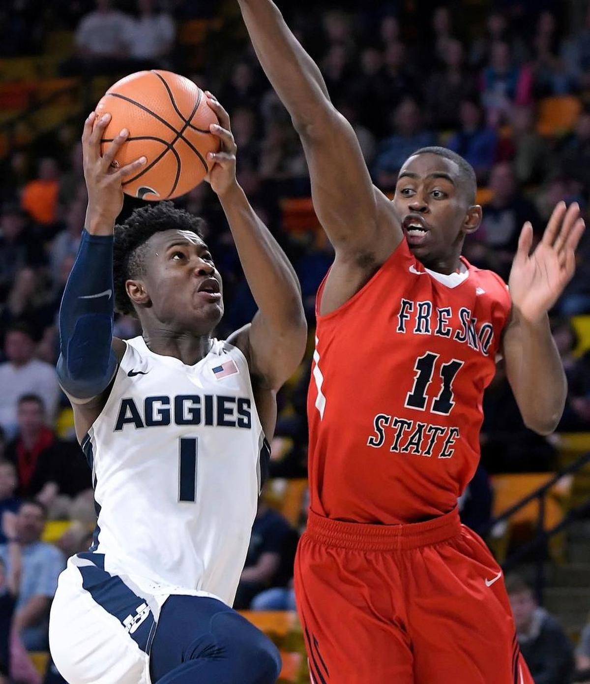 Fresno State forward Bryson Williams challenges a shot by Utah State guard Koby McEwen in the Bulldogs’ 81-79 overtime loss to the Aggies on Wednesday, Jan. 3, 2018, in Logan, Utah.