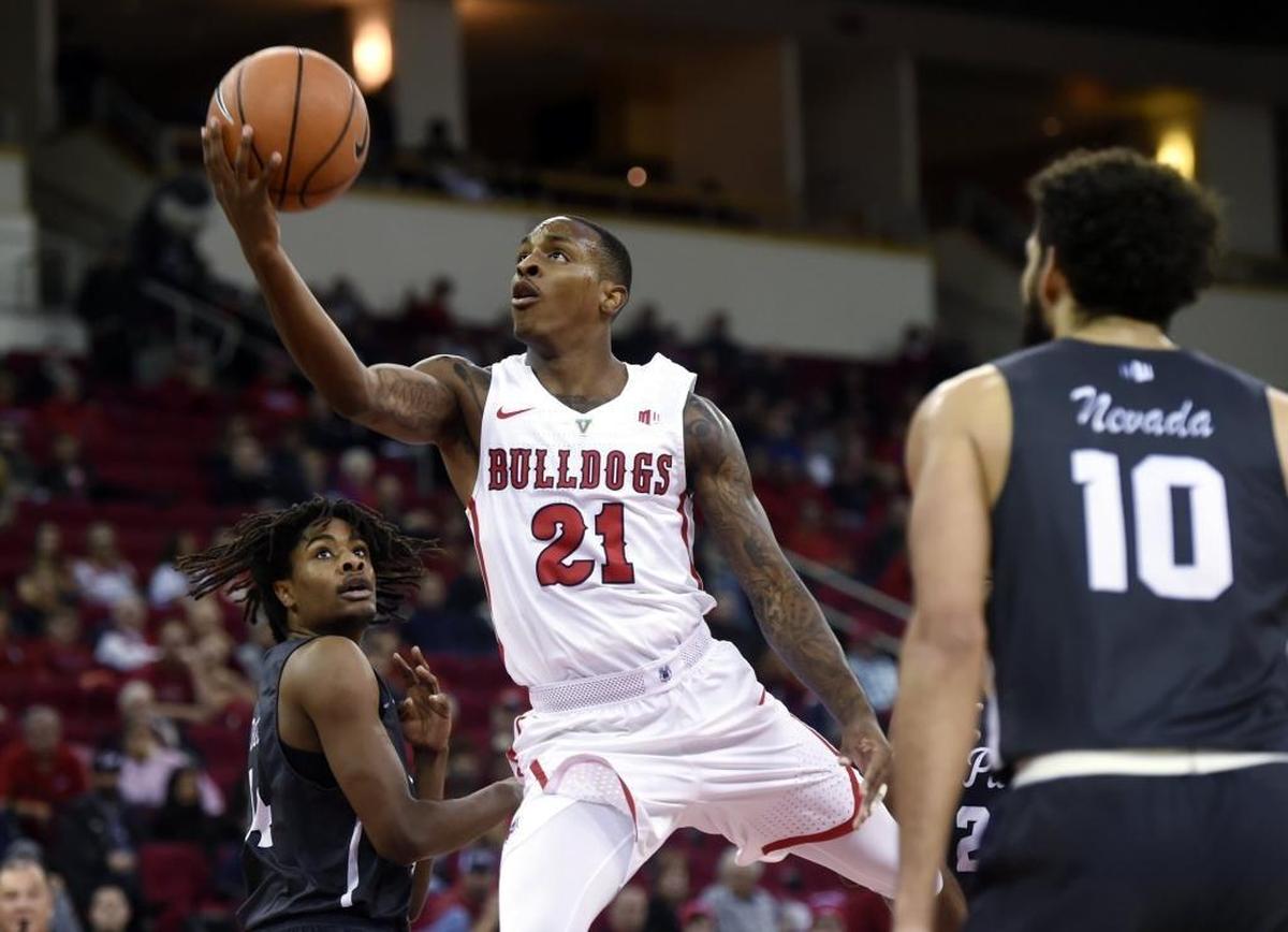 Fresno State guard Deshon Taylor drives for a layup between Nevada’s Lindsey Drew, left, and Caleb Martin, one of the few easy baskets the Bulldogs had in an 80-65 loss to the Wolf Pack on Wednesday, Dec. 27, 2017, at Save Mart Center.