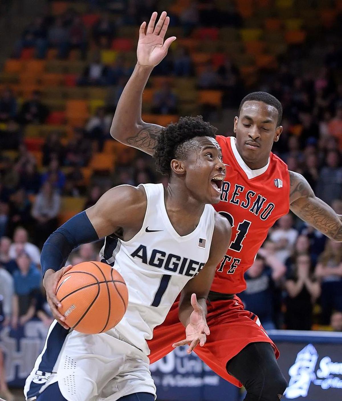 Utah State guard Koby McEwen (1) drives past Fresno State guard Deshon Taylor (21) on his way to the basket defends during the Aggies’ 81-79 overtime victory Wednesday, Jan. 3, 2018, in Logan, Utah. McEwen led all scorers with 28 points.