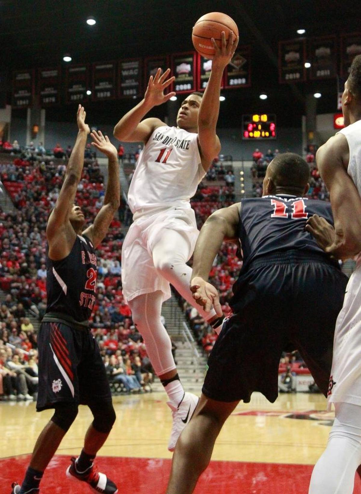 San Diego State's Matt Mitchell slices between Fresno State's Deshon Taylor, left, and Bryson Williams to the rim during the first half of the Bulldogs’ 77-73 victory over the Aztecs at Viejas Arena in San Diego on Wednesday, Jan. 17, 2018. San Diego State made a lay up or dunk on 10 of its first 13 madee baskets, but a defensive adjustment forced the Aztecs into tougher shots in the second half.