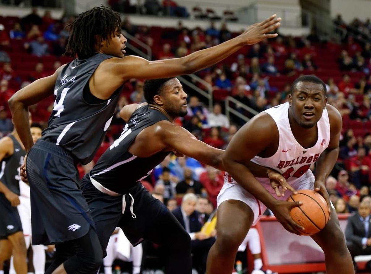 Fresno State ceenter Terrell Carter II tries to find a route to the basket between Nevada's Lindsey Drew, far left, and Jordan Caroline, center, in the Bulldogs’ 80-65 loss in their Mountain West Conference opener Wednesday, Dec. 27, 2017 in Fresno.