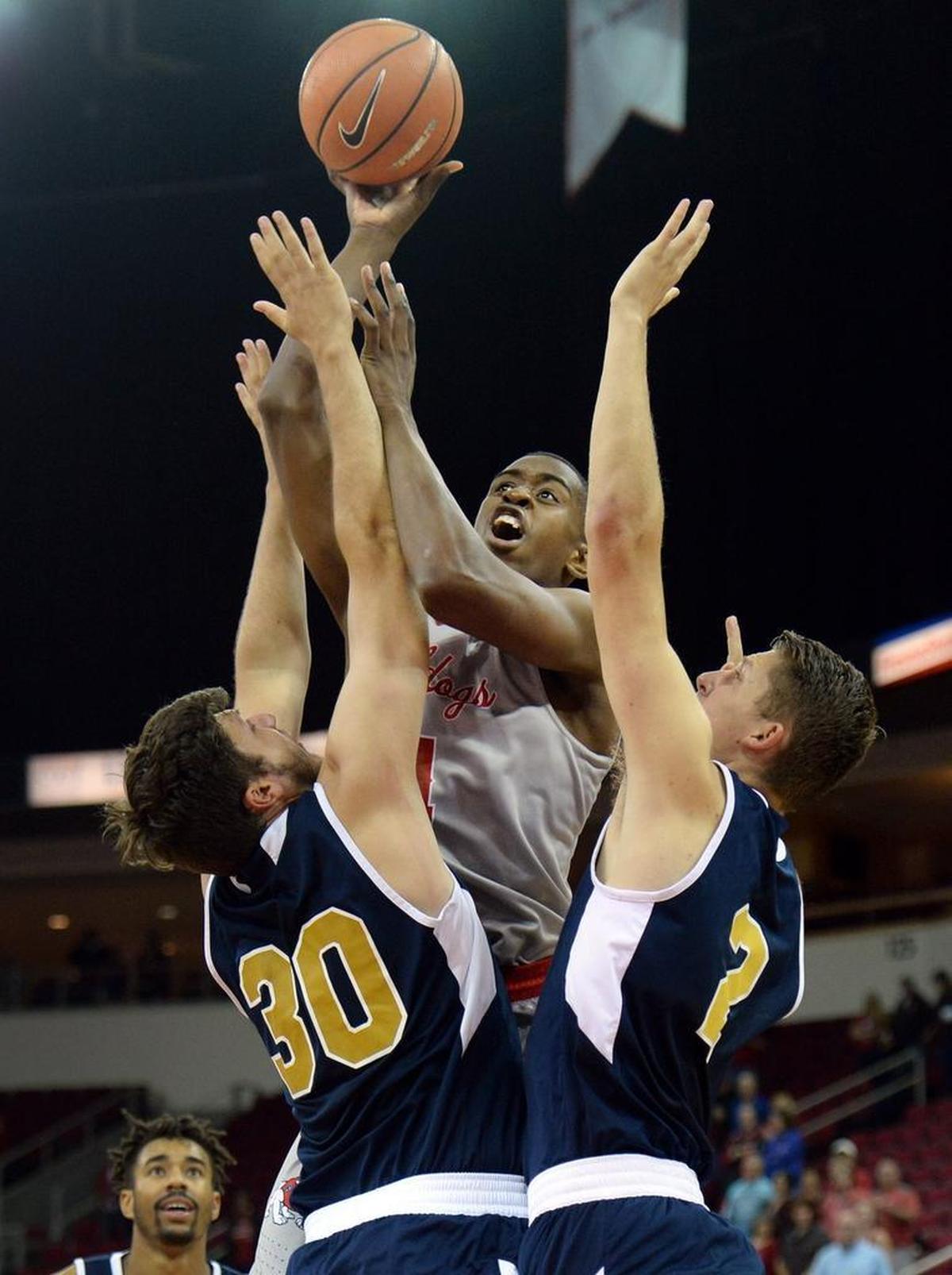 Fresno State forward Bryson Williams, center, puts up a shot while sandwiched between UC Merced’s Ronnie Kozak, left, and Aaron Laflin during the first half of a 79-39 exhibition victory at the Save Mart Center on Friday, Nov. 3, 2017. Williams is averaging 12.9 points and 7.9 rebounds for the Bulldogs.