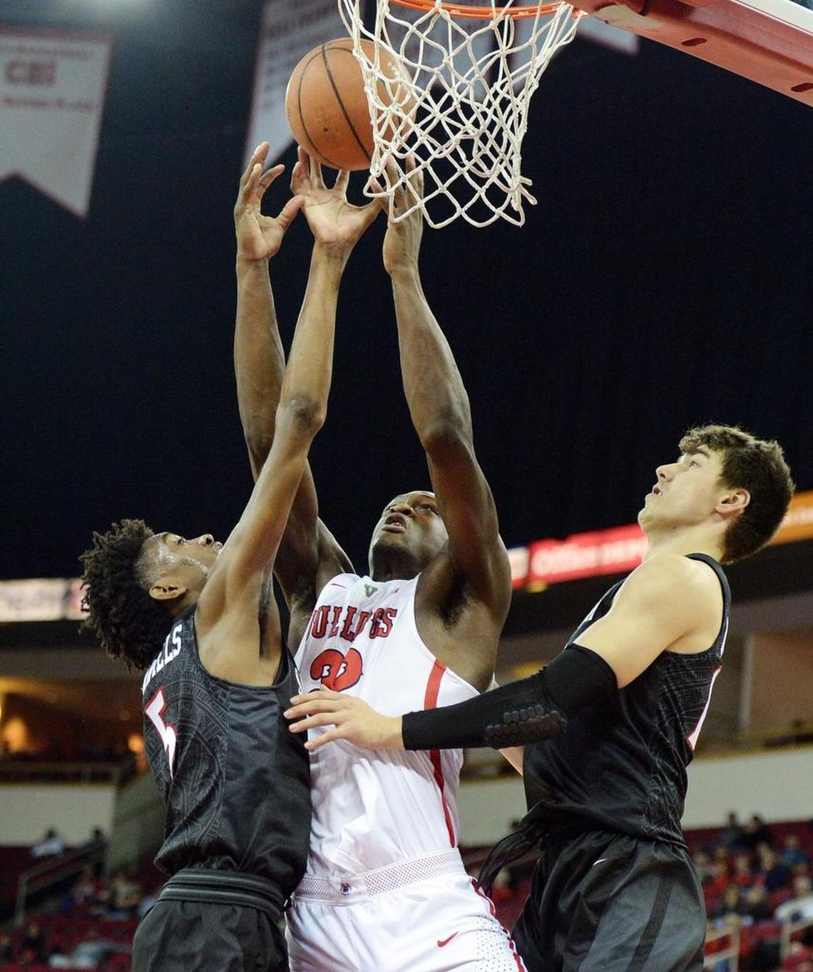Fresno State forwrad Nate Grimes, center, puts up a shot between San Diego State’s Jalen McDaniels, left, and Max Montana in the Bulldogs’ 79-61 victory over the Aztecs at the Save Mart Center in Fresno on Tuesday, Feb. 6, 2018.