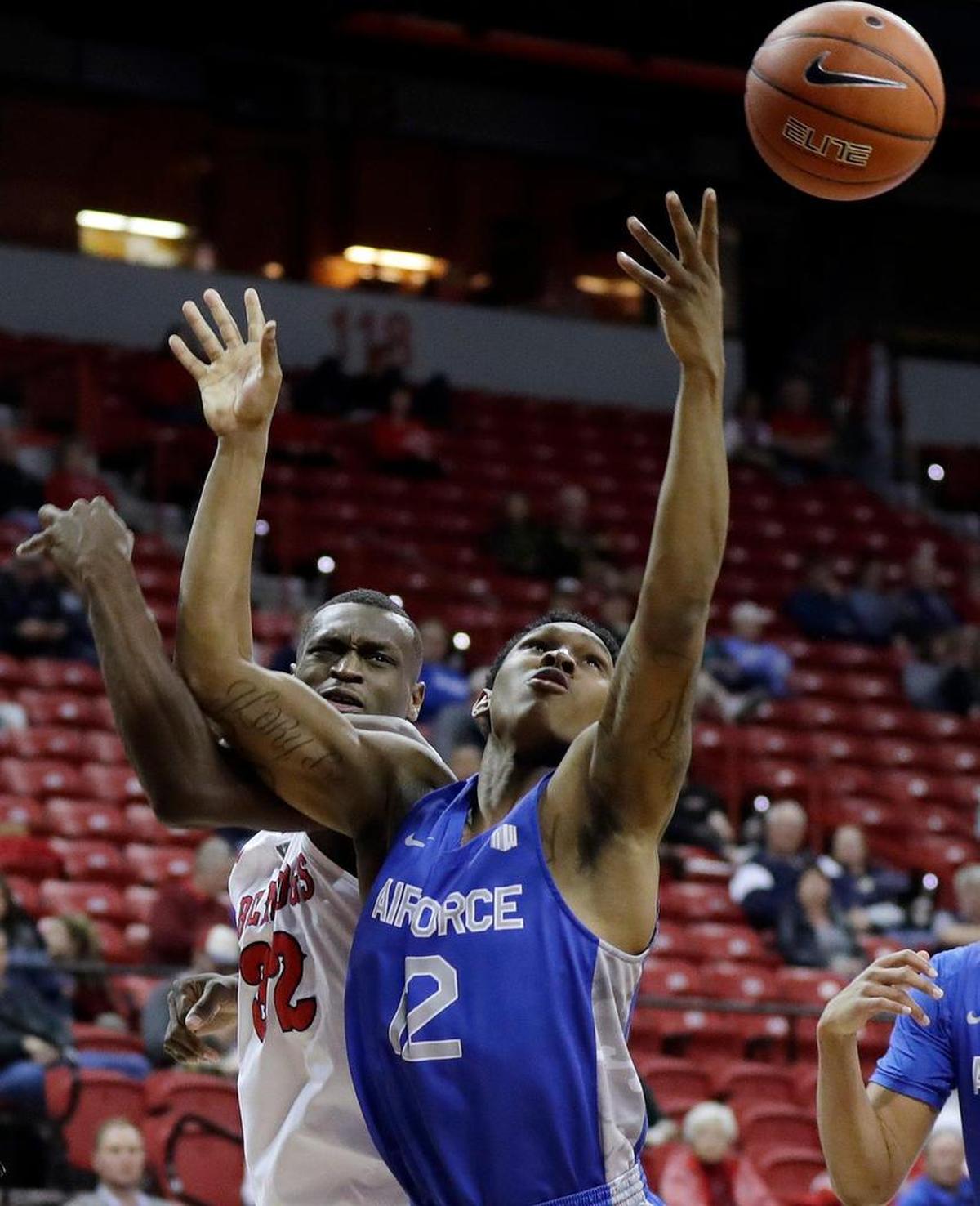Air Force’s Lavelle Scottie (12) and Fresno State’s Nate Grimes (32) reach for a rebound during the first half of an NCAA college basketball game in the Mountain West Conference men’s tournament Thursday, March 14, 2019, in Las Vegas. (AP Photo/Isaac Brekken)