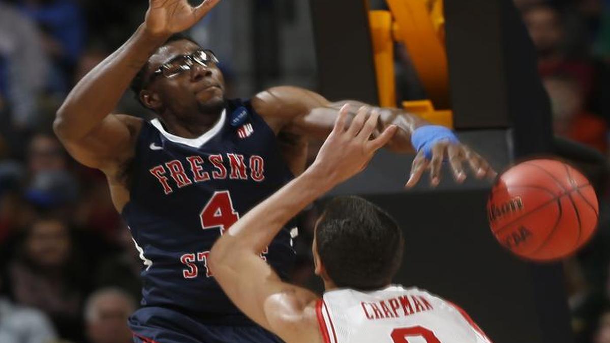 Fresno State forward Karachi Edo blocks a shot by Utah forward Brekkott Chapman in the second half of Thursday’s first-round NCAA Tournament game in Denver. Edo had three blocks in the Bulldogs’ 80-69 loss.