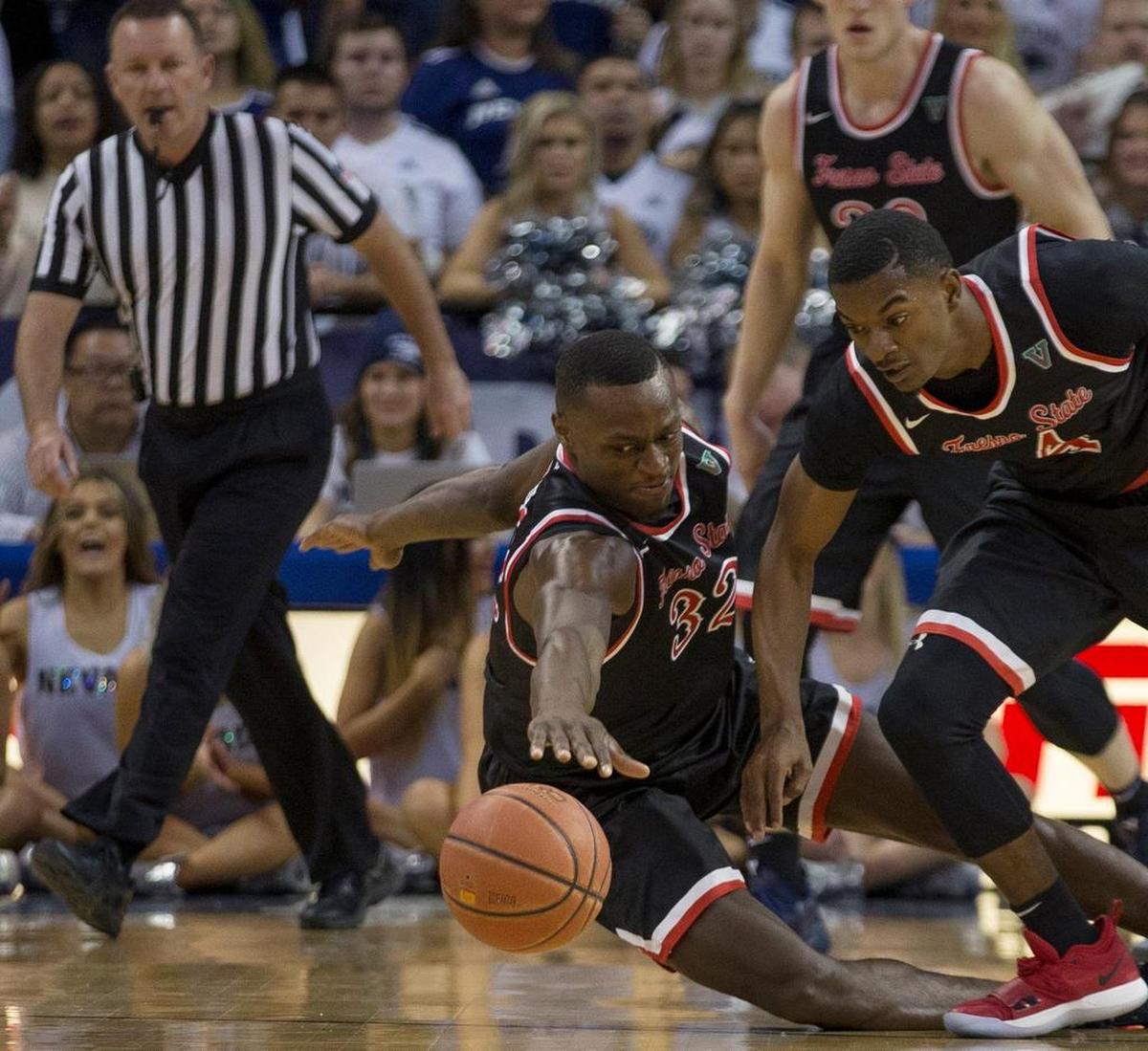 Fresno State forward Nate Grimes (32) and guard Braxton Huggins (4) scramble for the ball against Nevada in the first half of an NCAA college basketball game in Reno, Nev., Saturday, Feb. 23, 2019.